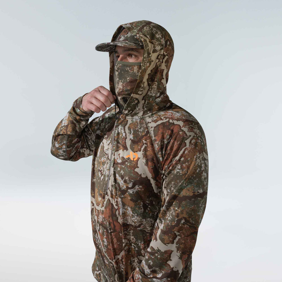 Camouflage long-sleeve hooded shirt with an integrated mesh face mask, quarter-zip, and orange chest logo.
