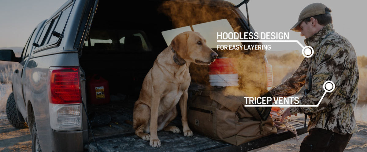 Camo hoodless jacket with tricep vents on man next to truck.