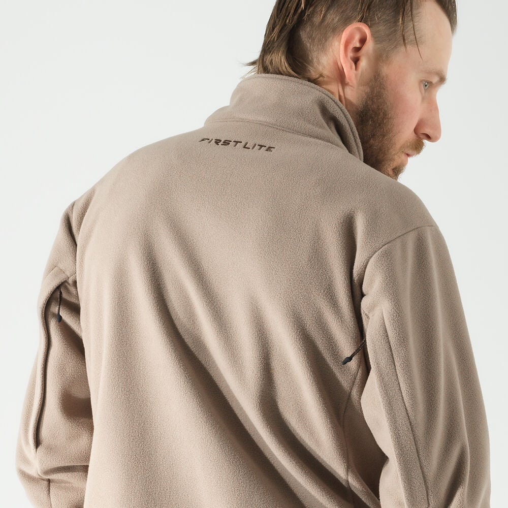 Tan fleece jacket with high collar, "FIRST LITE" logo on back, and side zipper.