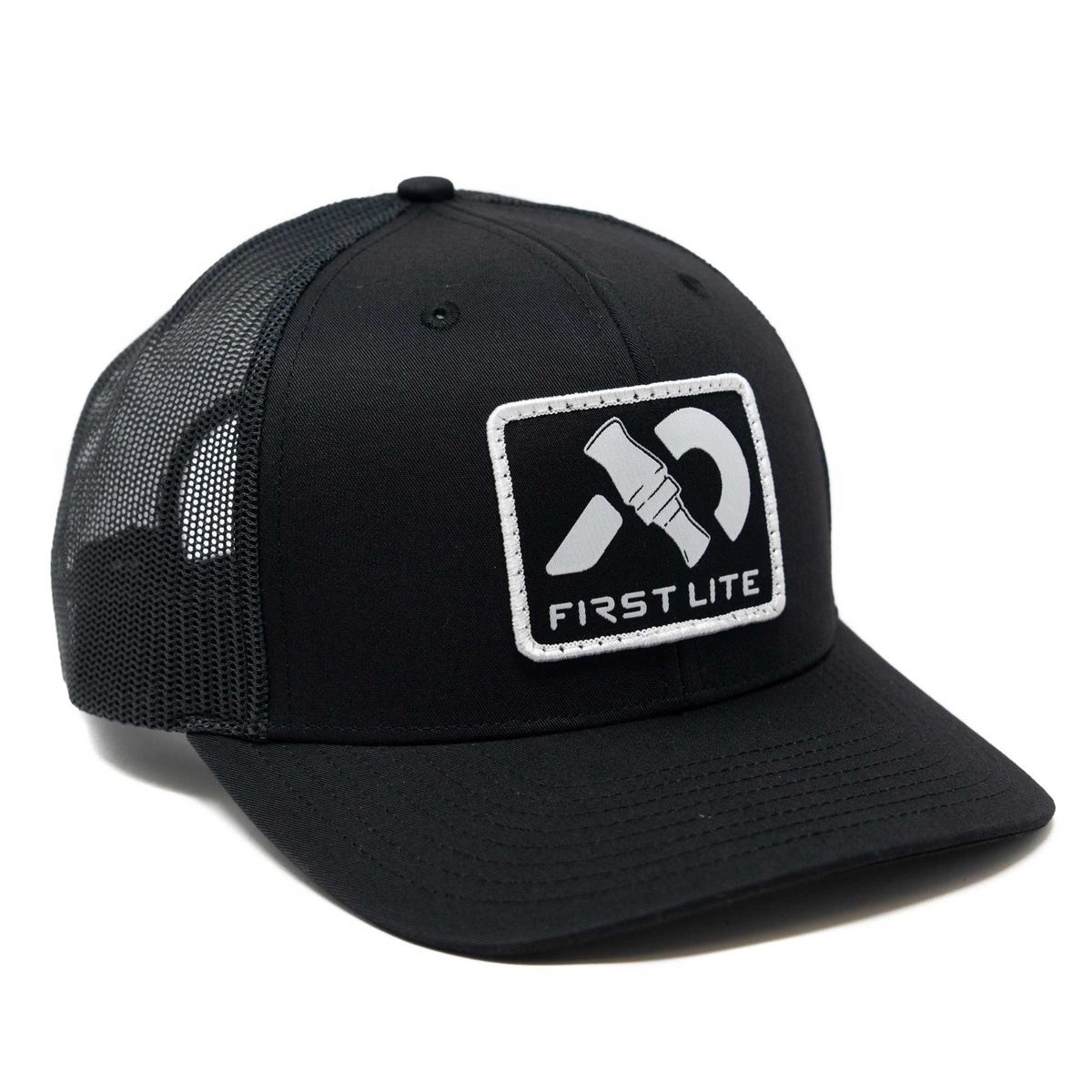 Black trucker hat with a white rectangular patch featuring a duck call graphic and the text "FIRST LITE".