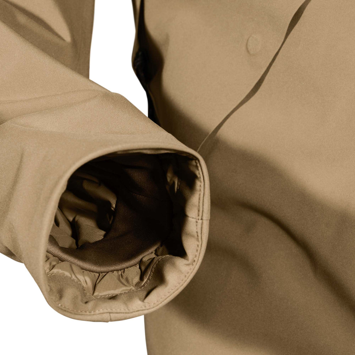 Close-up of a tan jacket sleeve cuff with a ribbed inner lining and visible stitching, next to a subtle circular detail on the jacket body.