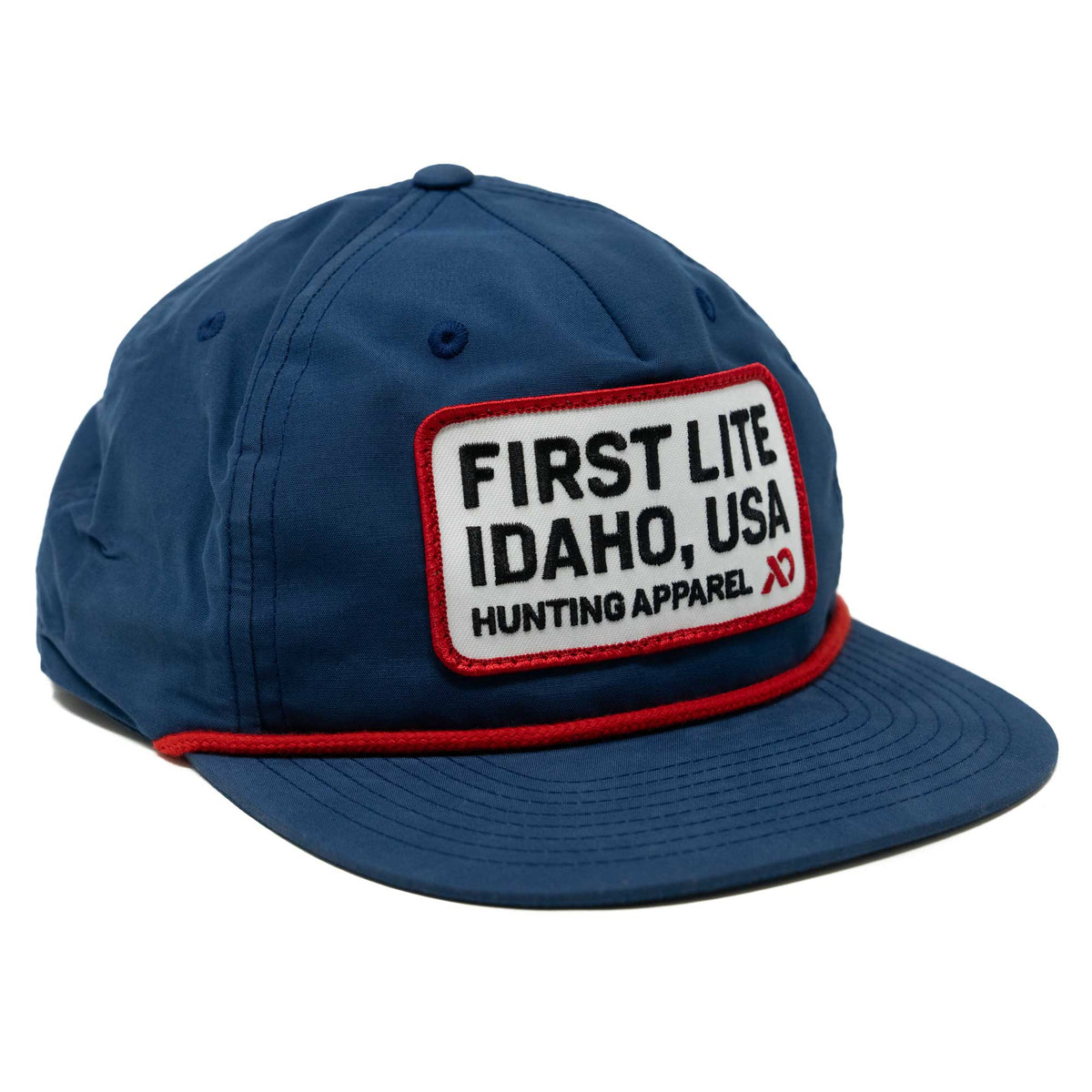 Dark blue cap with a red rope accent and a white rectangular patch embroidered with 'FIRST LITE IDAHO, USA HUNTING APPAREL'.