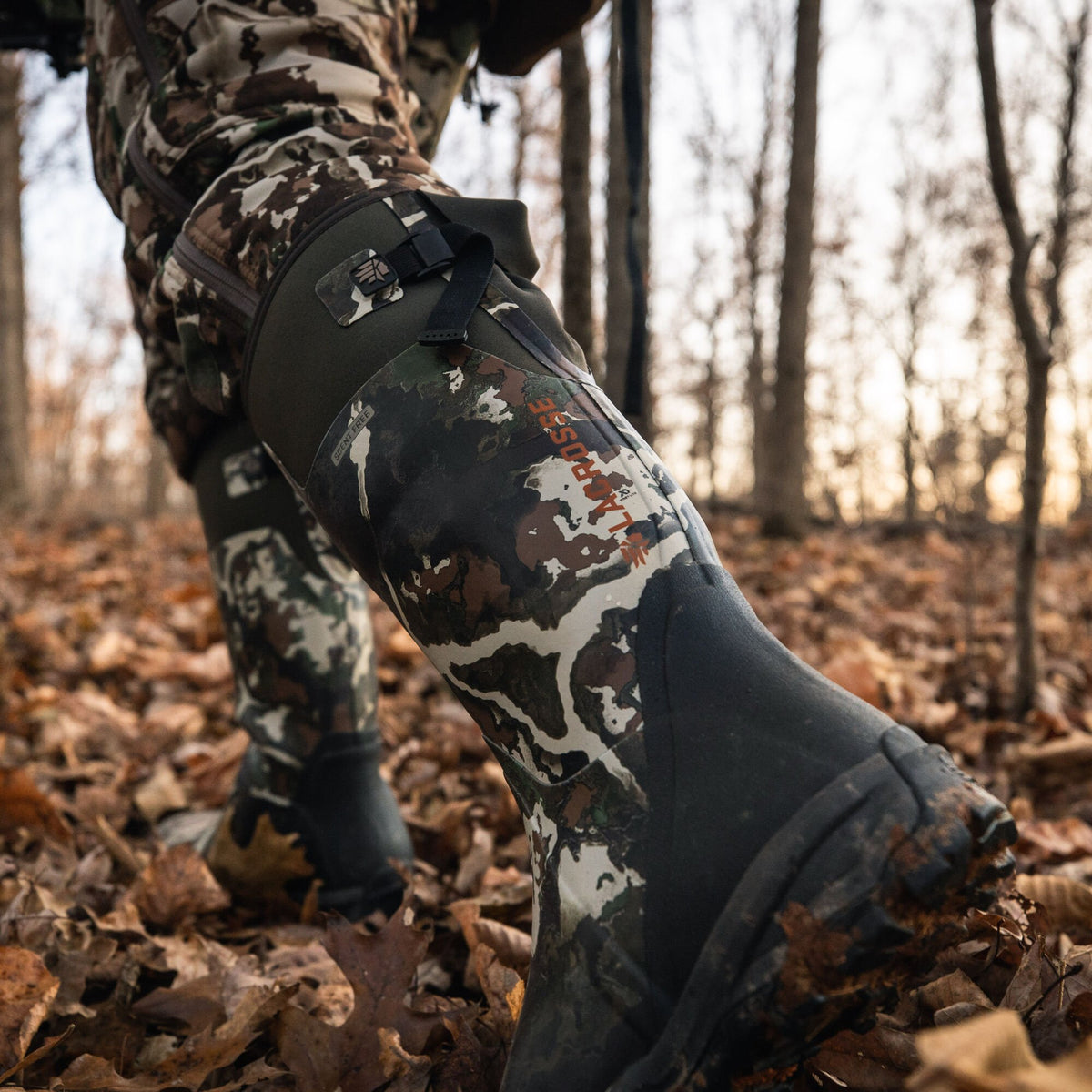 Tall LaCrosse camouflage hunting boots with black rubber soles, dark green adjustable cuffs, and Scent Free branding.
