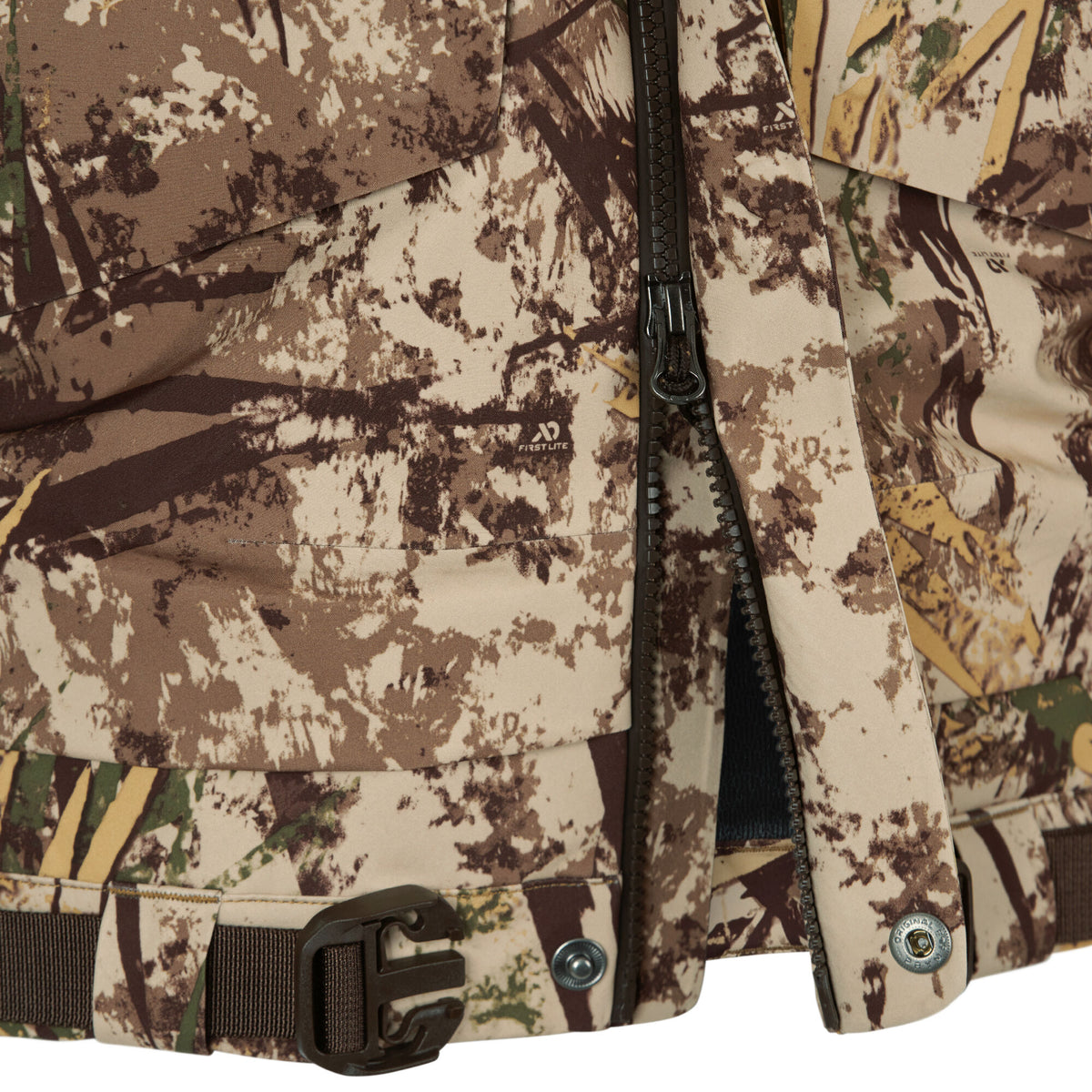 Brown and beige camouflage hunting jacket featuring a dark zipper, visible First Lite logo, and a dark buckle strap.