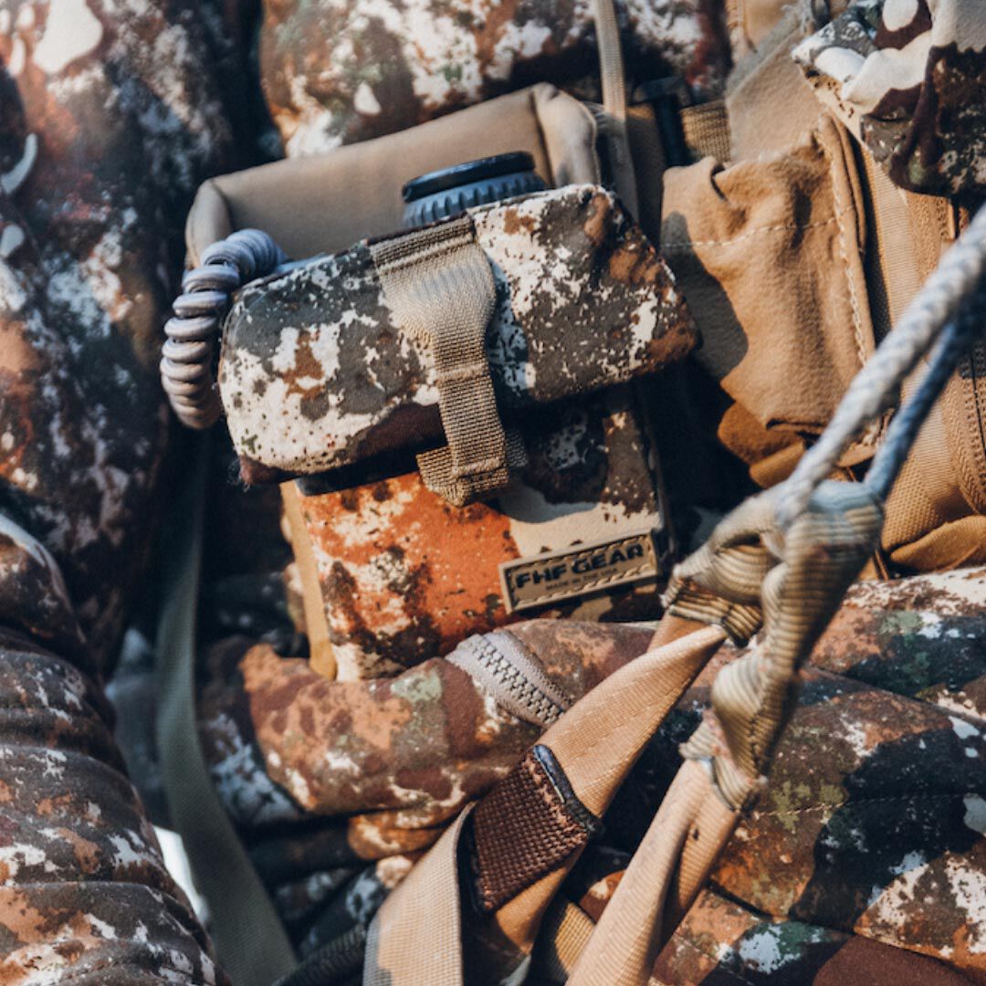 Brown, white, and green camouflage FHF GEAR chest harness with a front pouch and coiled lanyard.