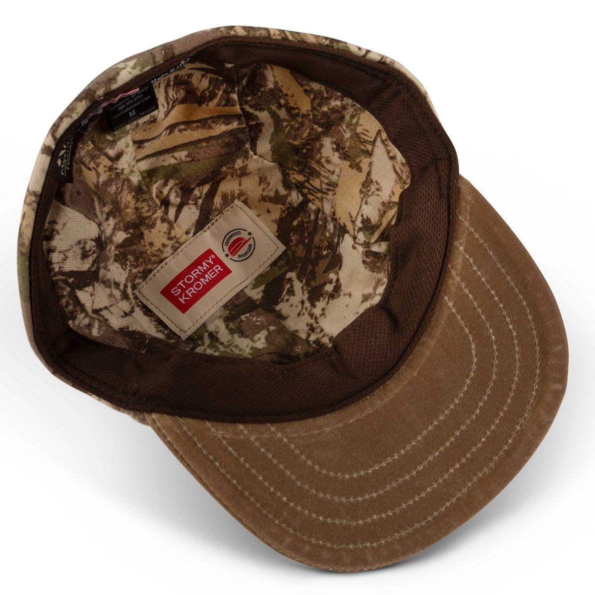 Camouflage cap interior showing a brown brim, mesh sweatband, and Stormy Kromer label.