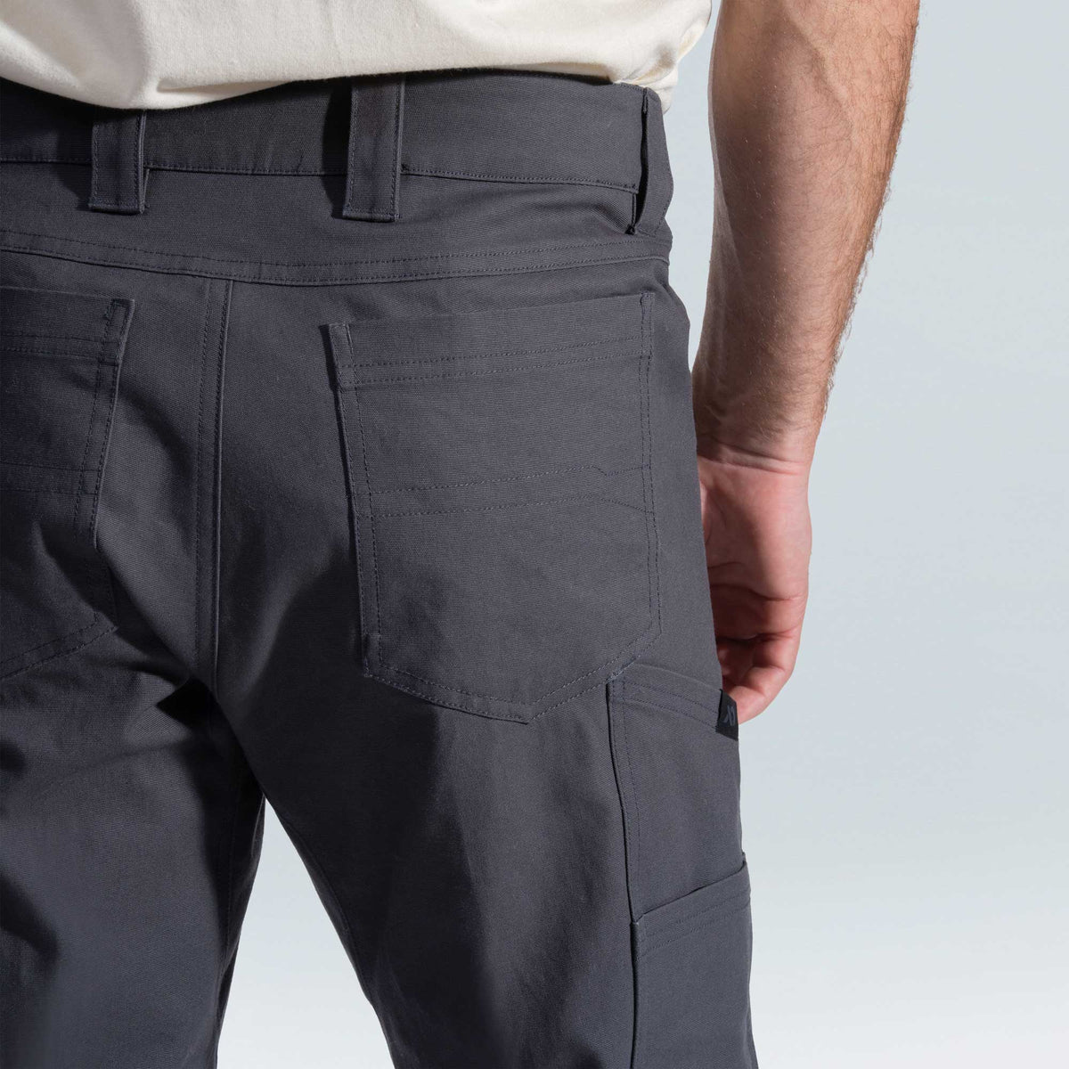 Close-up of dark gray pants on a plain background