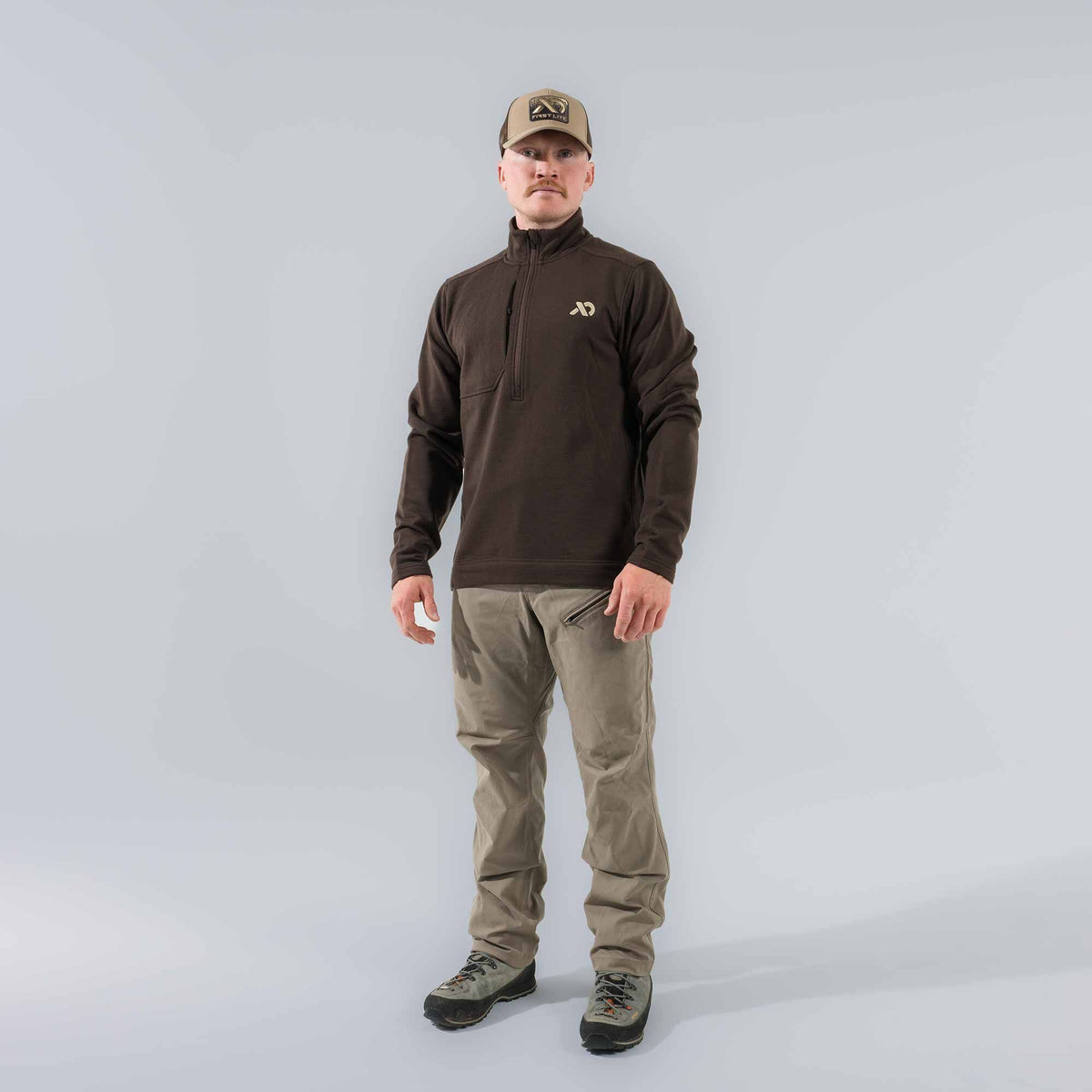 Dark brown men's quarter-zip pullover with a high collar, chest zipper pocket, and an XD logo on the left chest.
