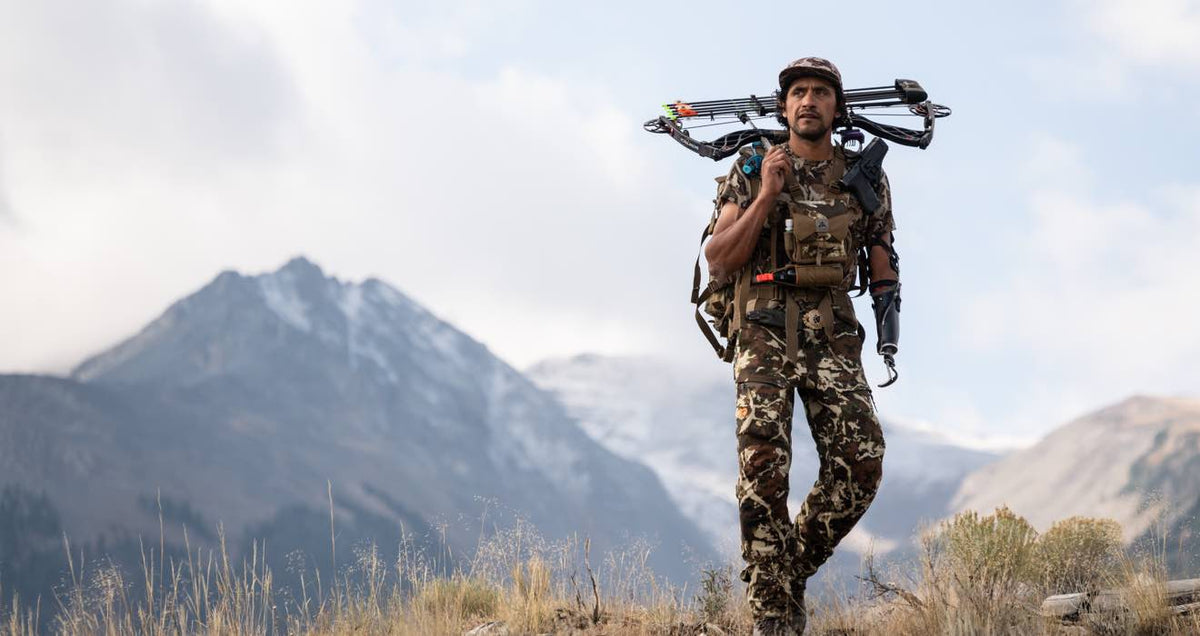 Hunter in brown camouflage, with a crossbow and prosthetic arm.