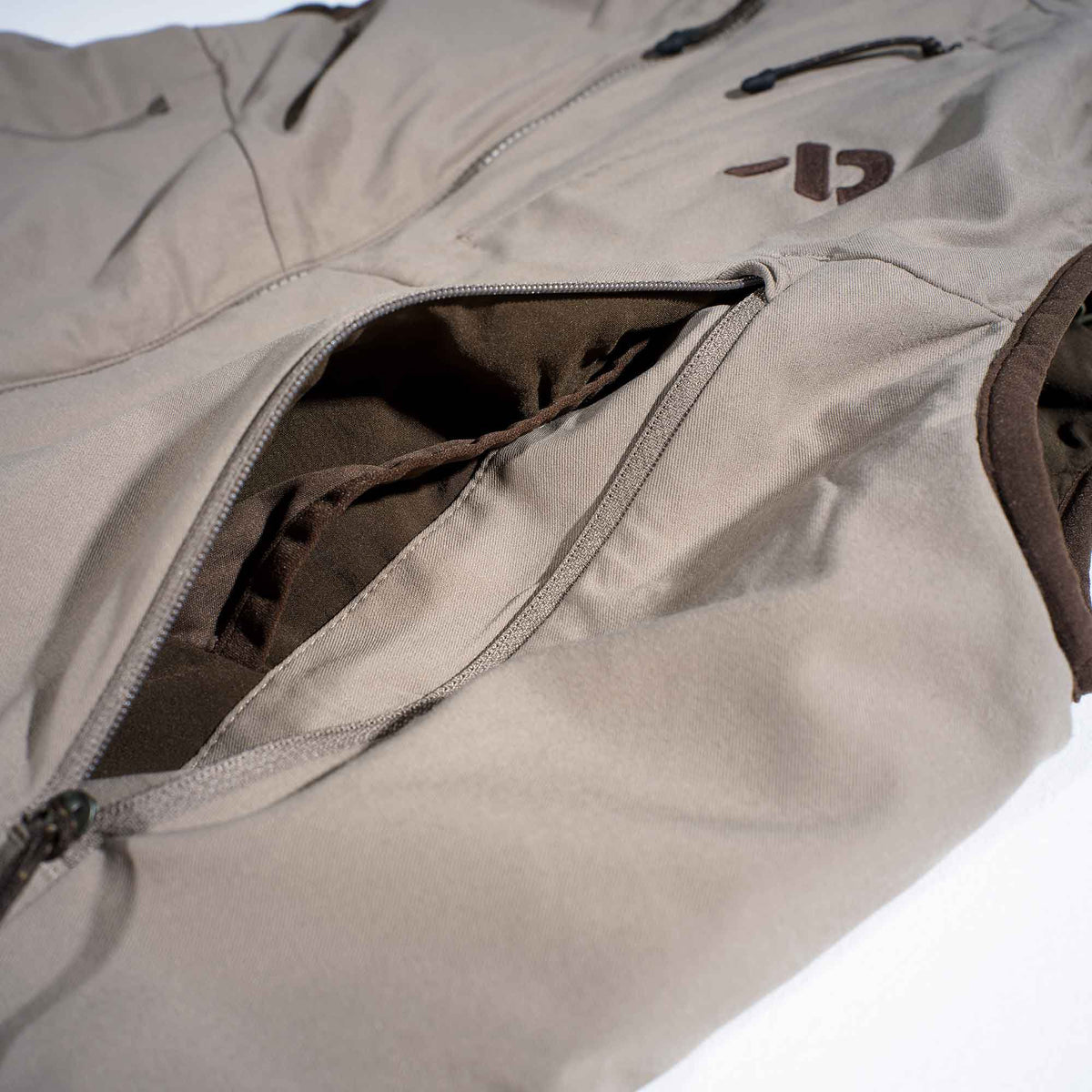 Walnut vest with an open zippered pocket revealing dark brown lining, a dark brown logo, and dark brown trim.