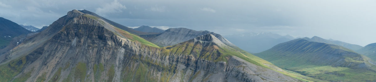 Panoramic view of a mountain landscape with rugged peaks and valleys.