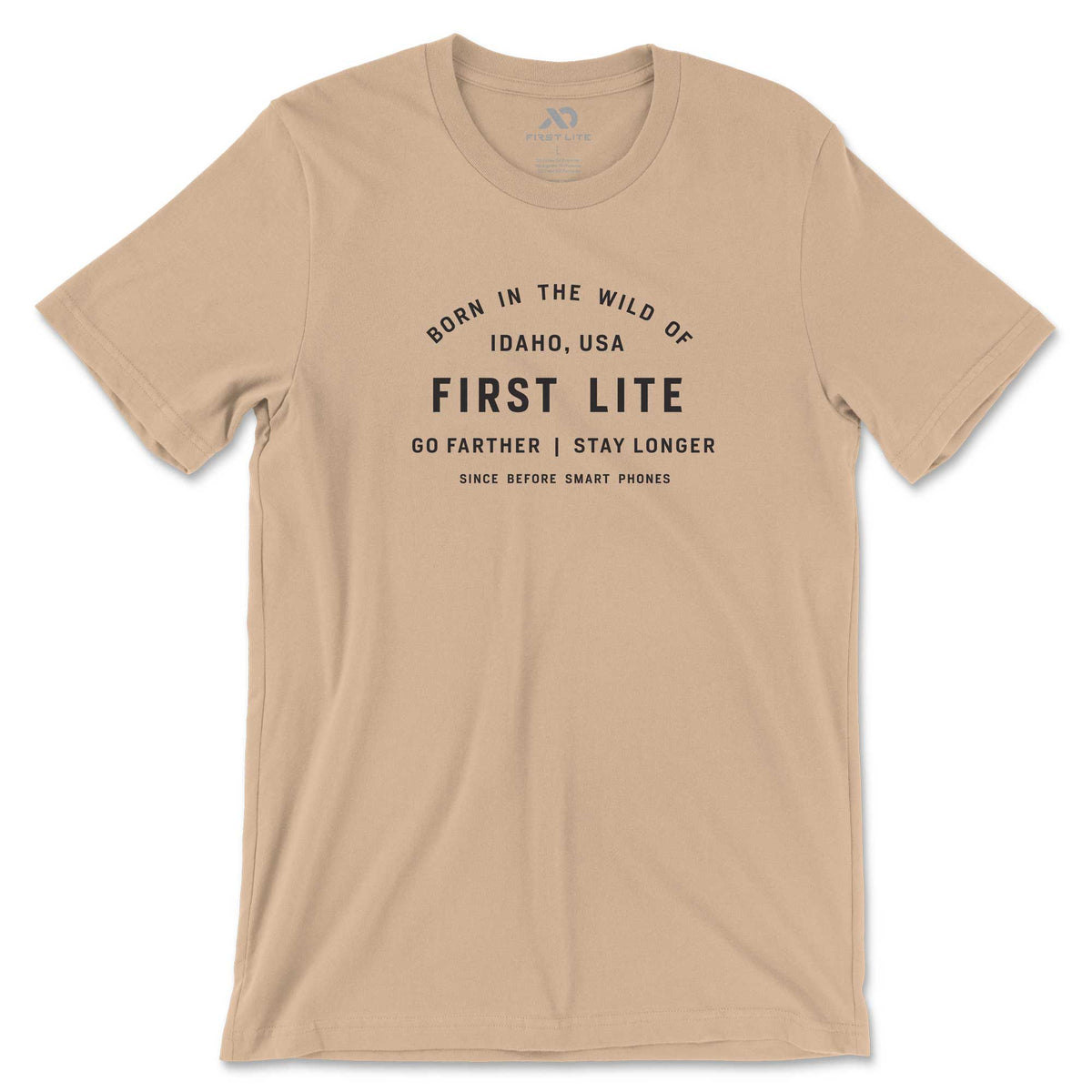 Tan t-shirt with black text that reads 'Born in the wild of Idaho, USA FIRST LITE GO FARTHER | STAY LONGER SINCE BEFORE SMART PHONES'.