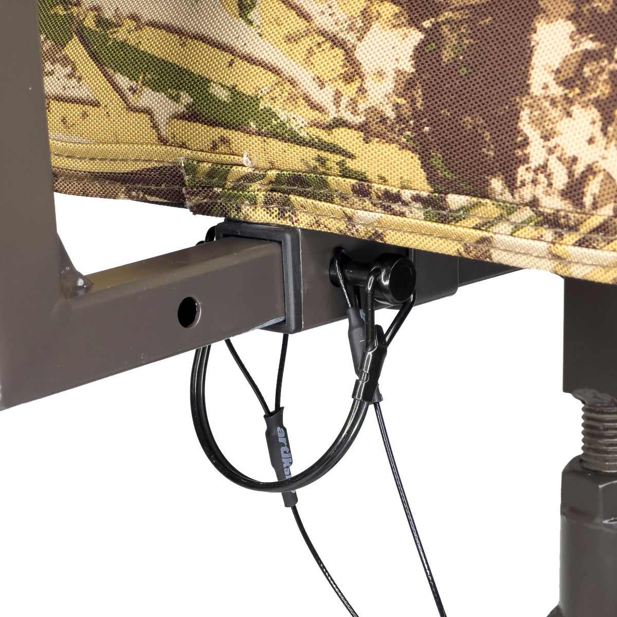 Camouflage fabric cover connected to a dark grey metal frame with a black coiled cable lock attached.