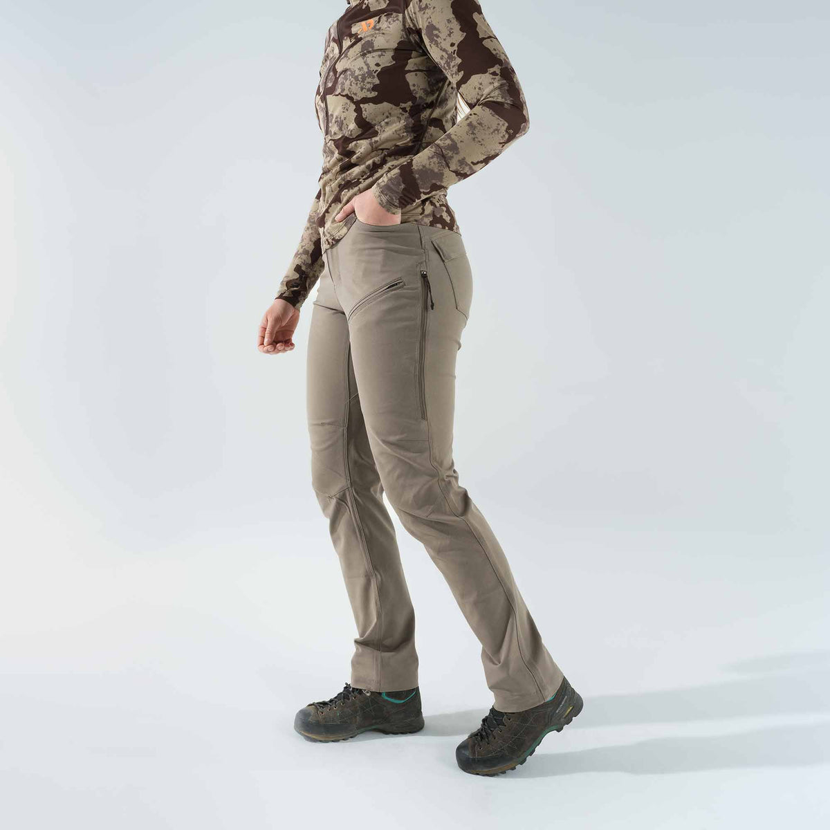 Khaki women's hiking pants with zippered thigh pockets and articulated knees.