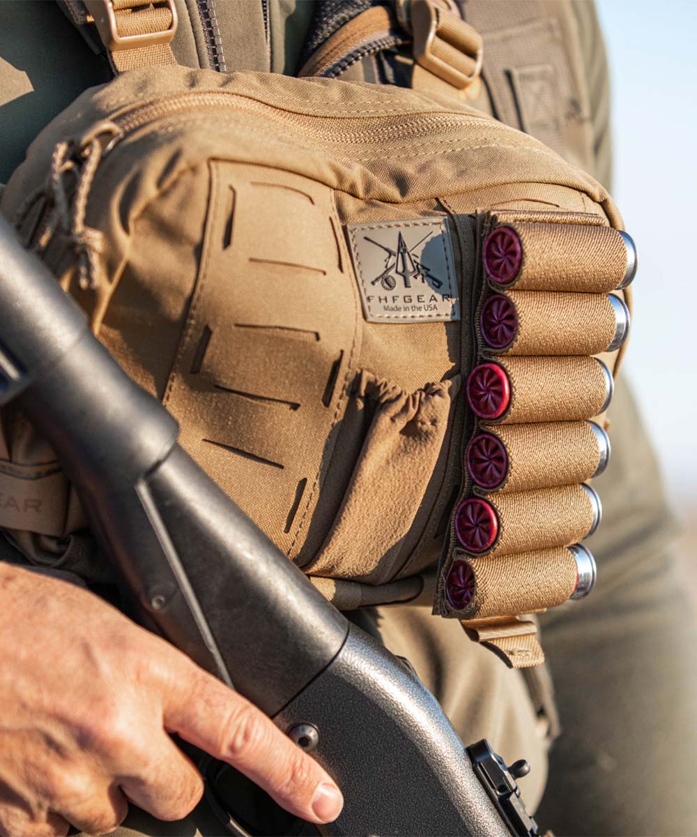 A tan FHF GEAR chest pouch featuring MOLLE-style webbing and a side holder with 6 red-tipped shotgun shells, worn by a person holding a shotgun.