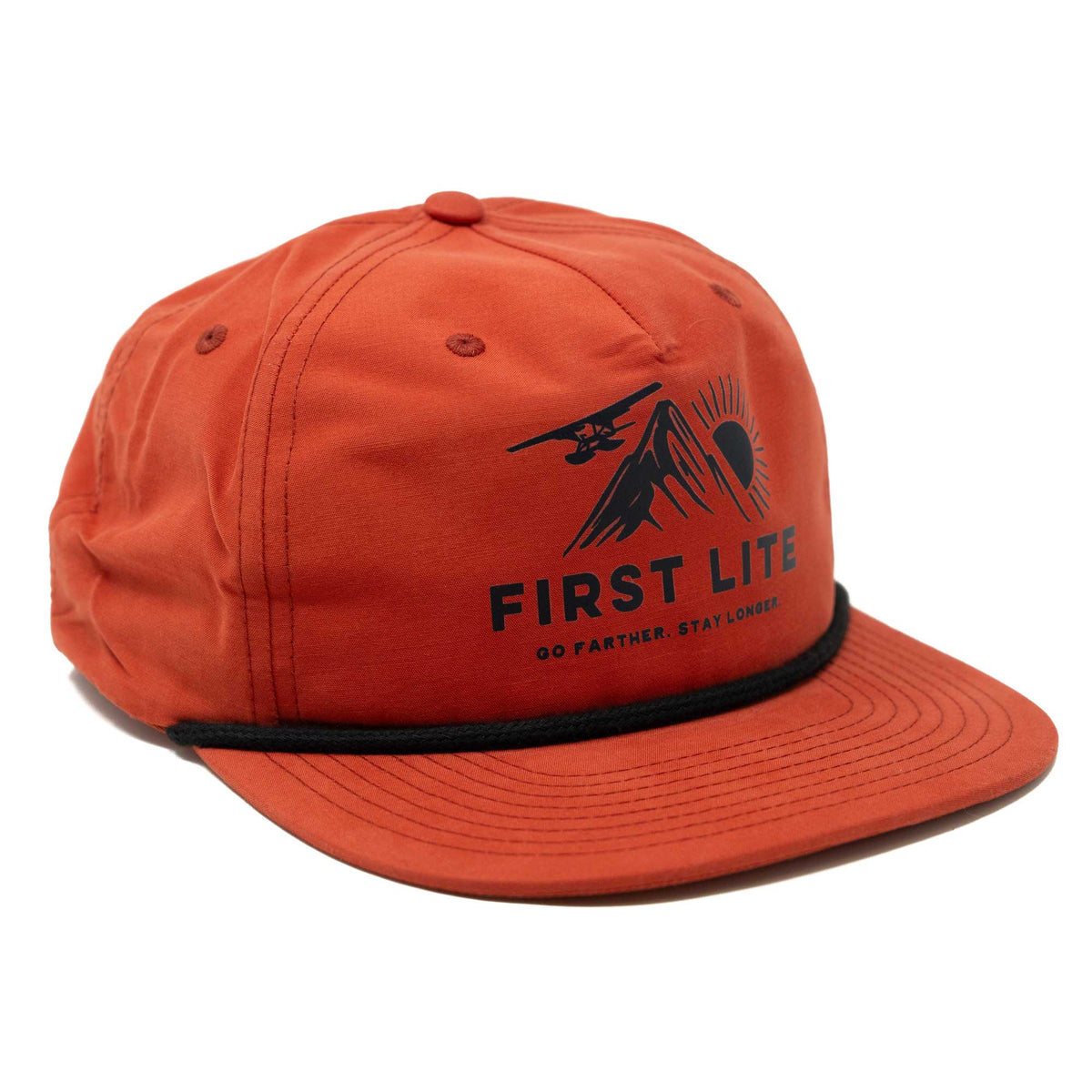 Burnt orange cap with a black rope trim and a 'FIRST LITE' graphic featuring a mountain, sun, and airplane.