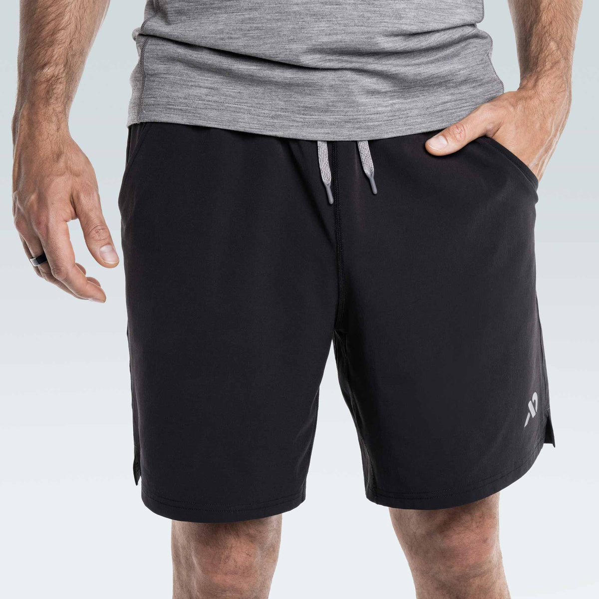 Person wearing black shorts with a First Lite logo on a light gray background