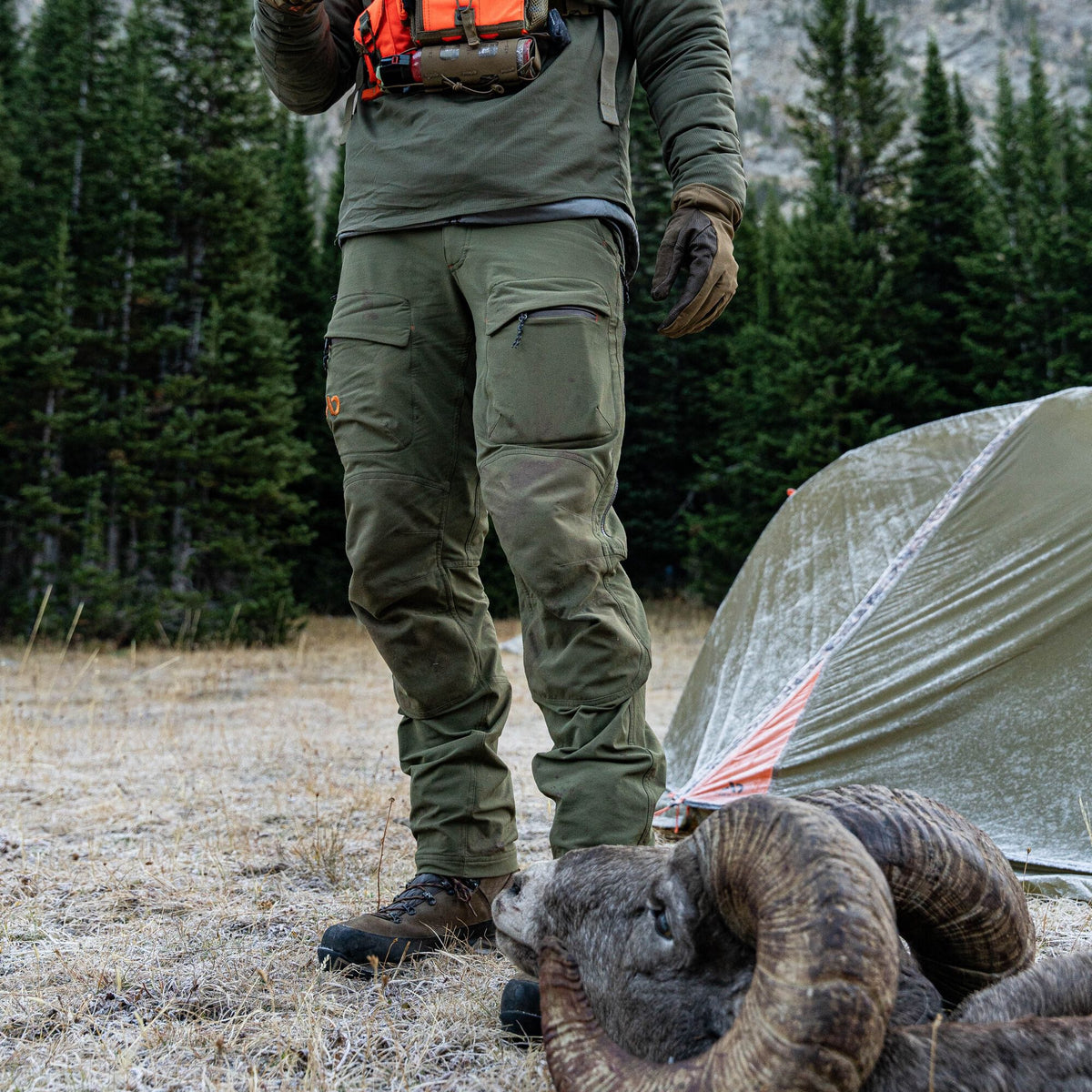 Olive green outdoor pants featuring reinforced knees, cargo pockets, and a zippered leg pocket.