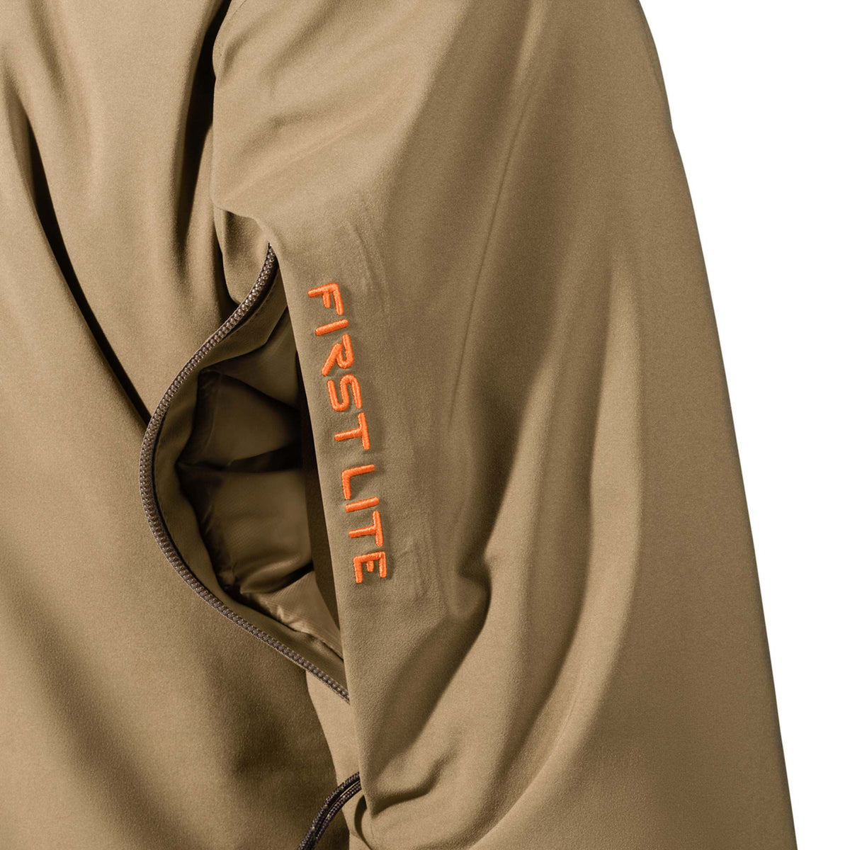 Tan jacket sleeve with orange "FIRST LITE" embroidery and a partially unzipped vertical pocket.