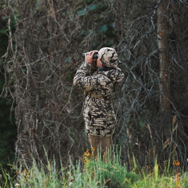 Grey camo puffy jacket & beanie worn by person observing with binoculars.