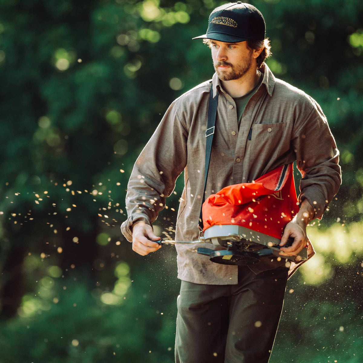 Man operating a seeder in a forest setting
