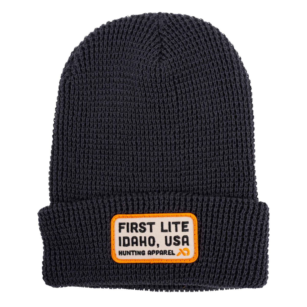 Dark grey ribbed knit beanie with a folded cuff and a beige square patch featuring the text "FIRST LITE IDAHO, USA Hunting Apparel"