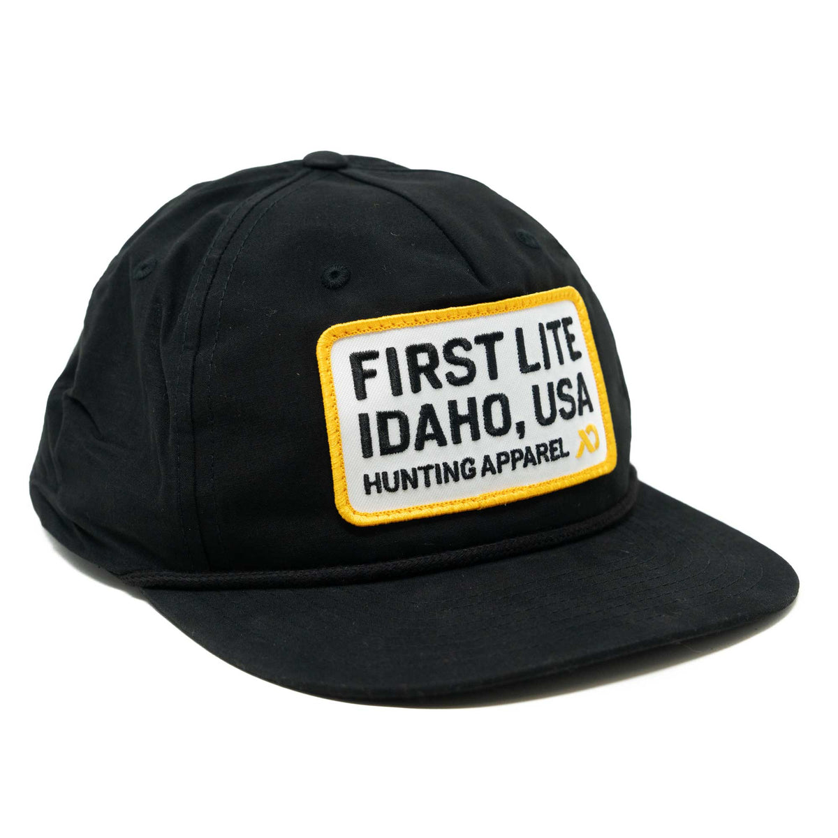 Black cap with a white, yellow-bordered rectangular patch on the front that reads 'FIRST LITE IDAHO, USA HUNTING APPAREL' and has a yellow logo, plus a black rope above the brim.