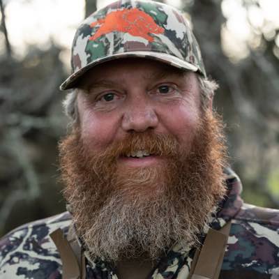 Camouflage baseball cap with an orange hog logo.