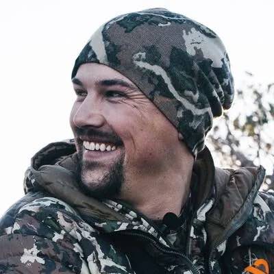 Slouchy camouflage beanie worn by smiling man.