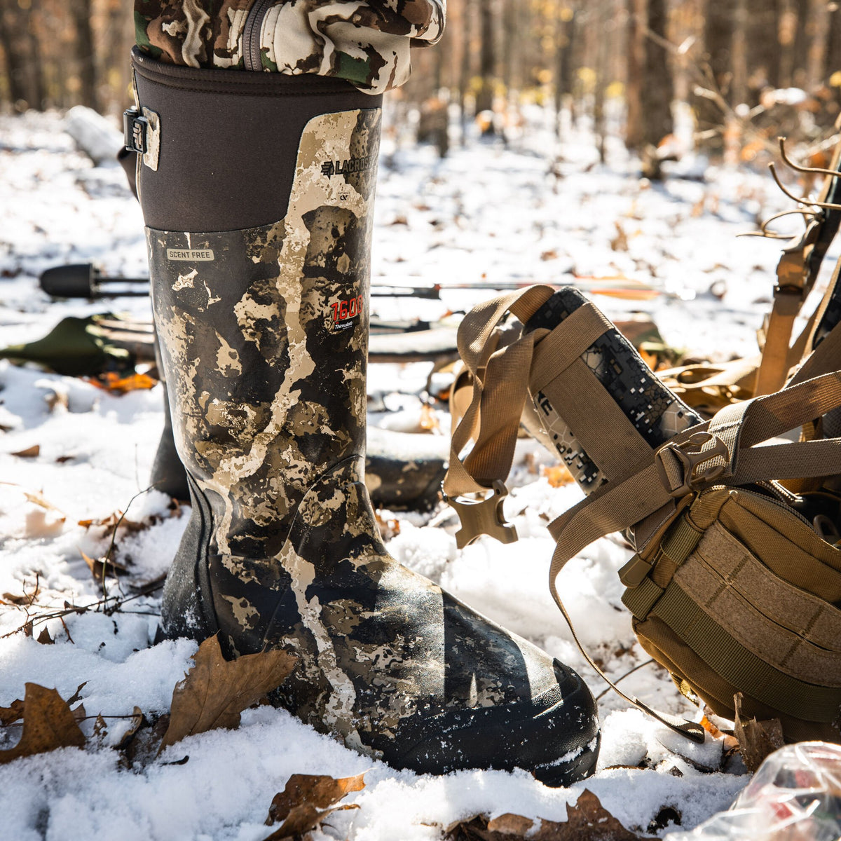 LaCrosse camouflage rubber hunting boot with "Scent Free" and "1600 Thinsulate" labels stands in light snow.