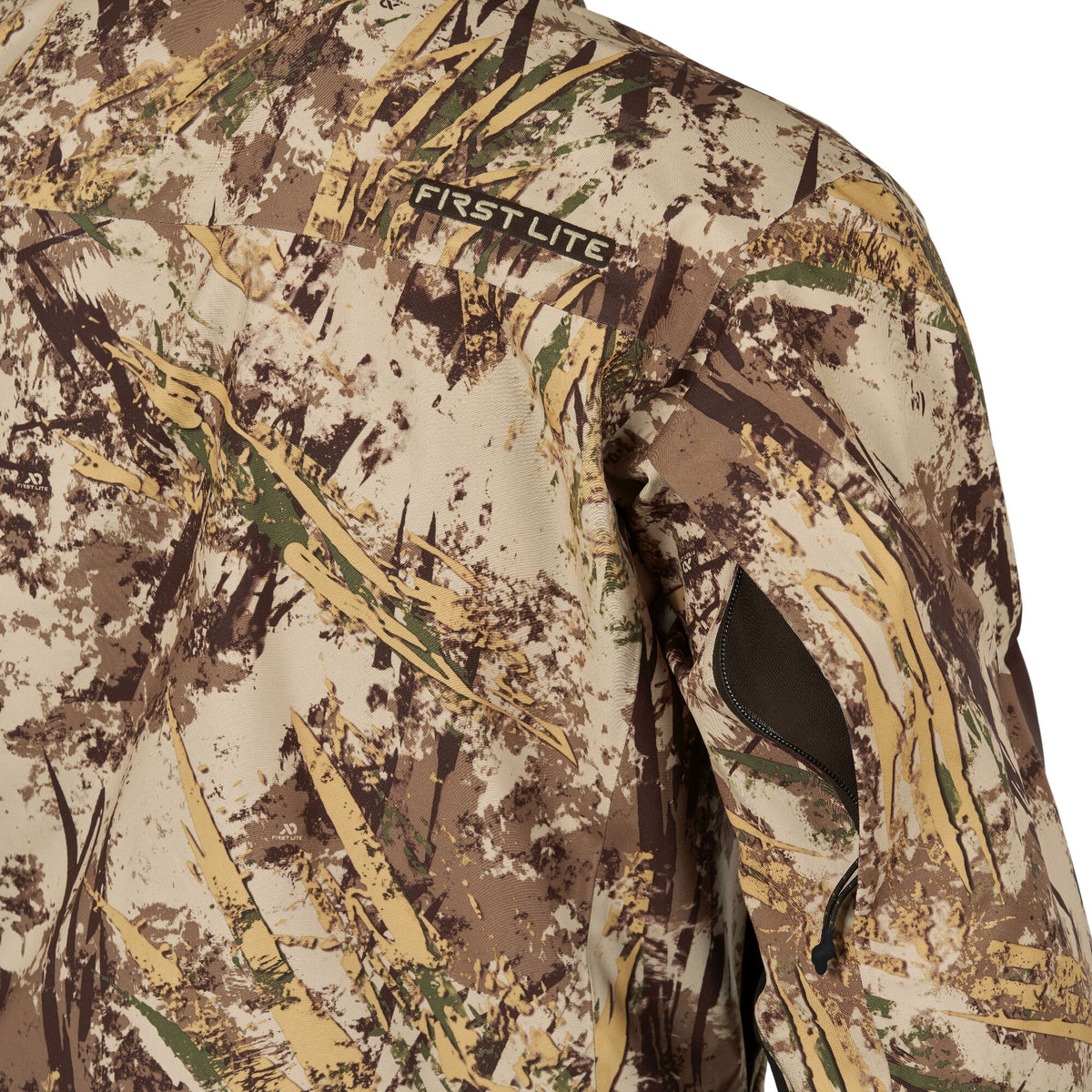 First Lite hunting jacket in a tan, brown, and green camouflage pattern, featuring the brand logo and a zippered sleeve pocket.