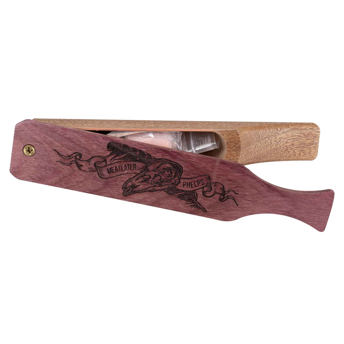 Open purple and light brown wooden turkey box call with skull and "MEATEATER PHELPS" engraving, revealing small accessories inside.