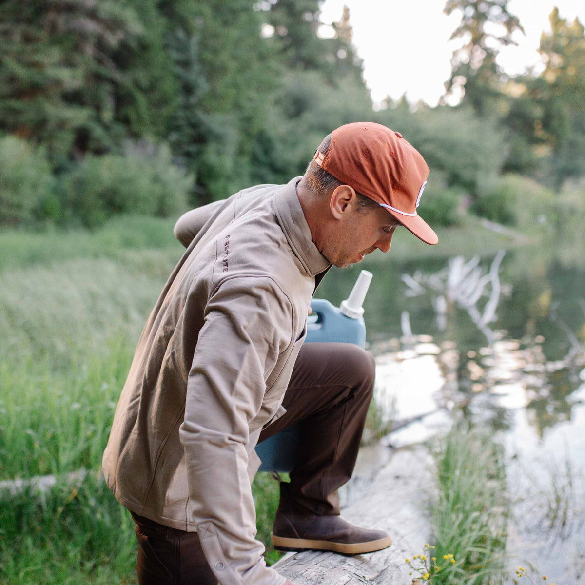 Beige quarter-zip pullover shirt with a stand-up collar and "FIRST LITE" text on the left shoulder.