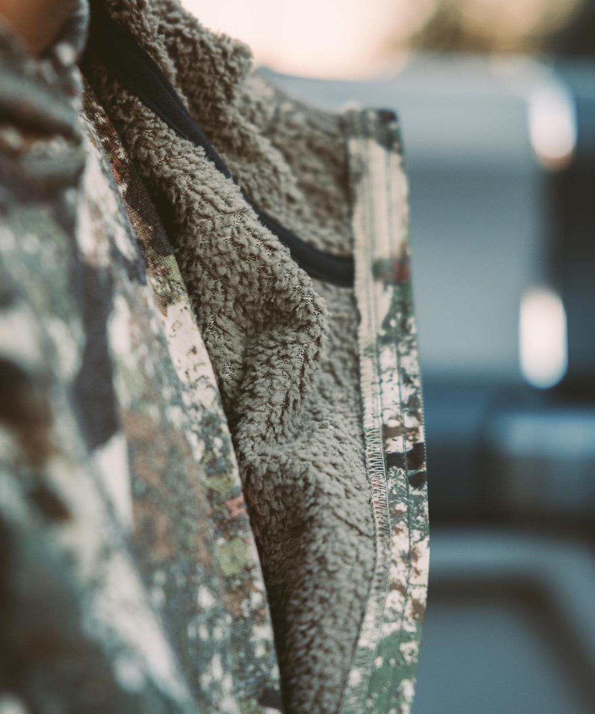 Camo jacket with olive sherpa fleece lining and black trim.