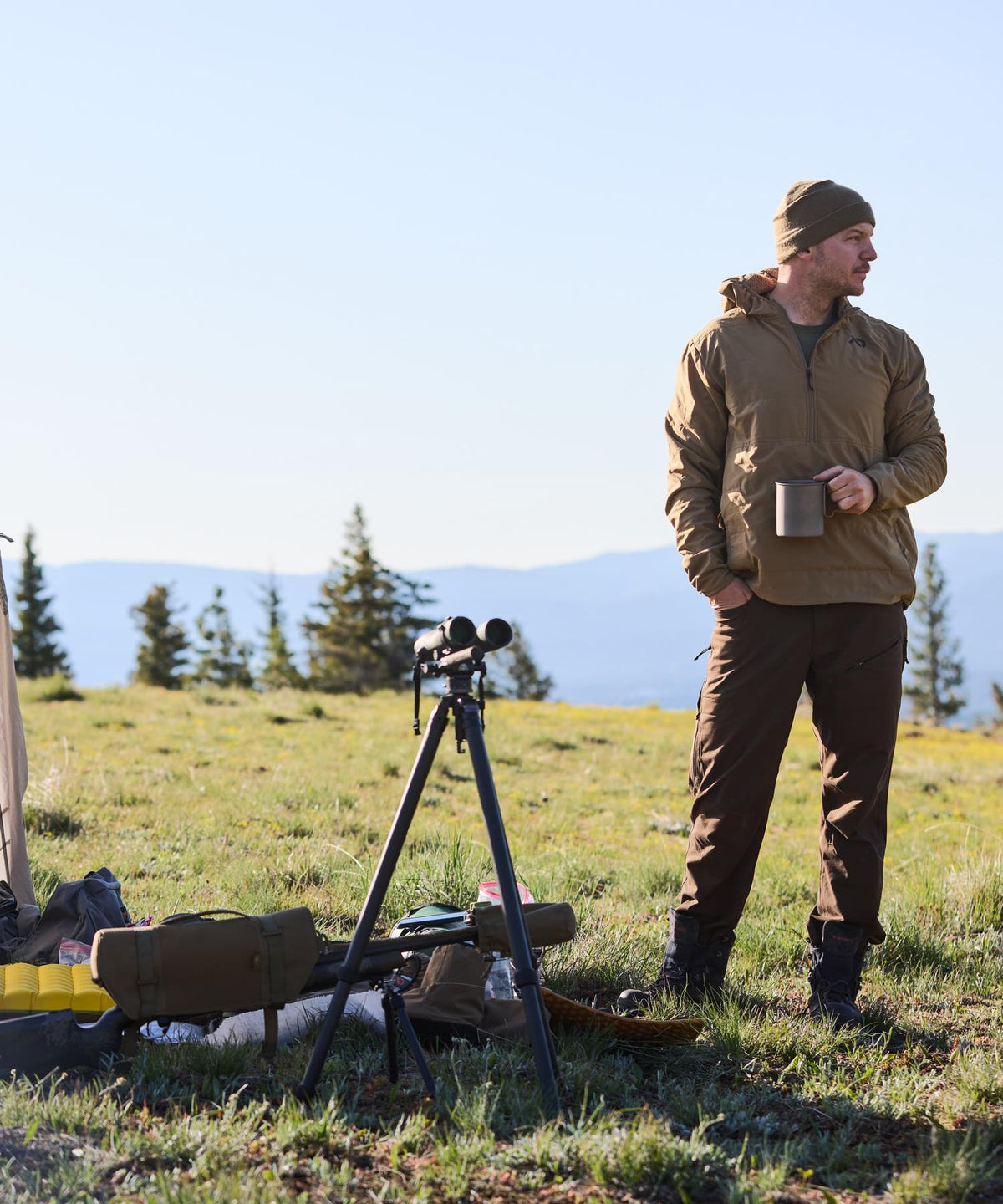 Coyote hooded quarter-zip anorak jacket worn by a man outdoors.
