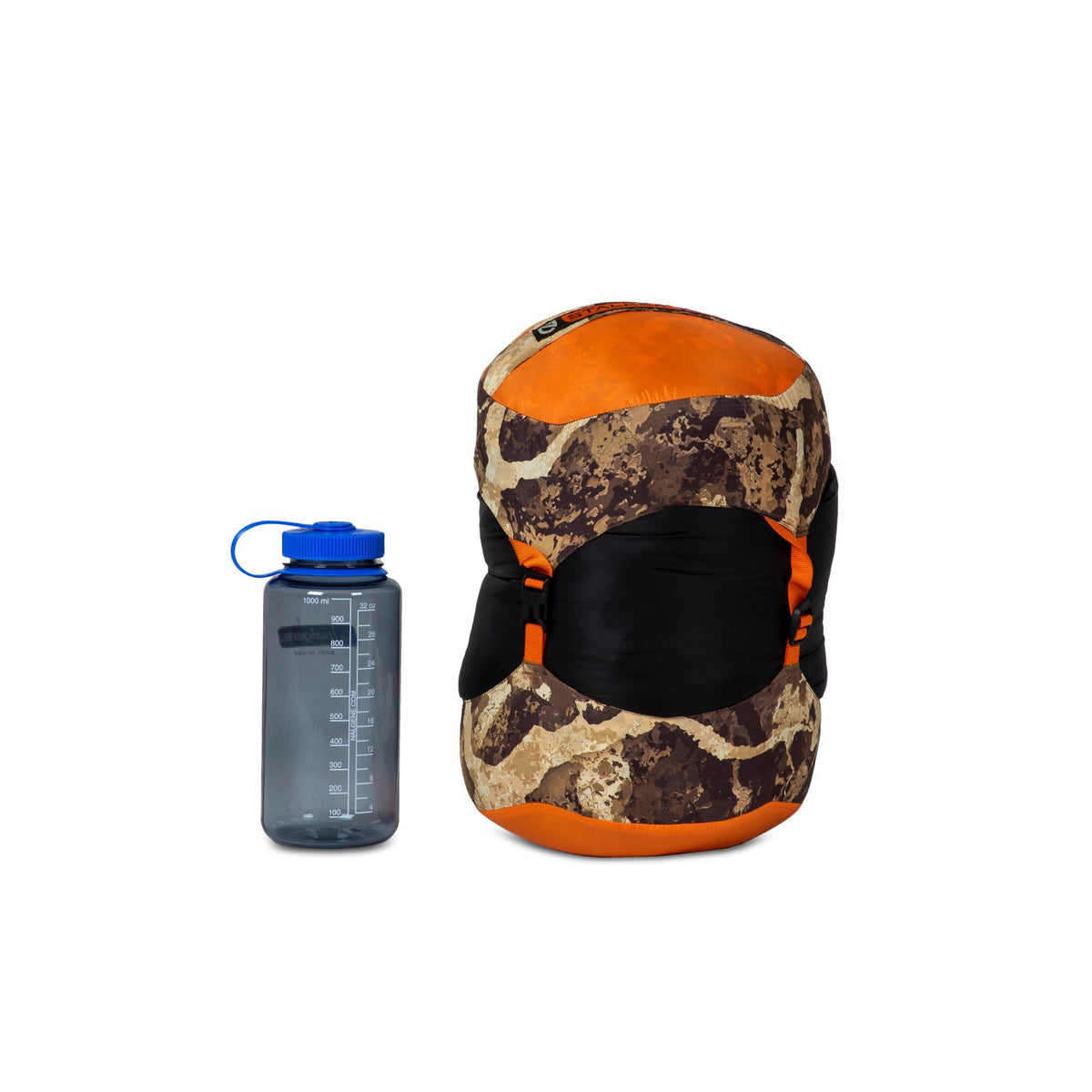 An orange and camouflage compression sack with black straps and buckles sits beside a gray Nalgene water bottle.