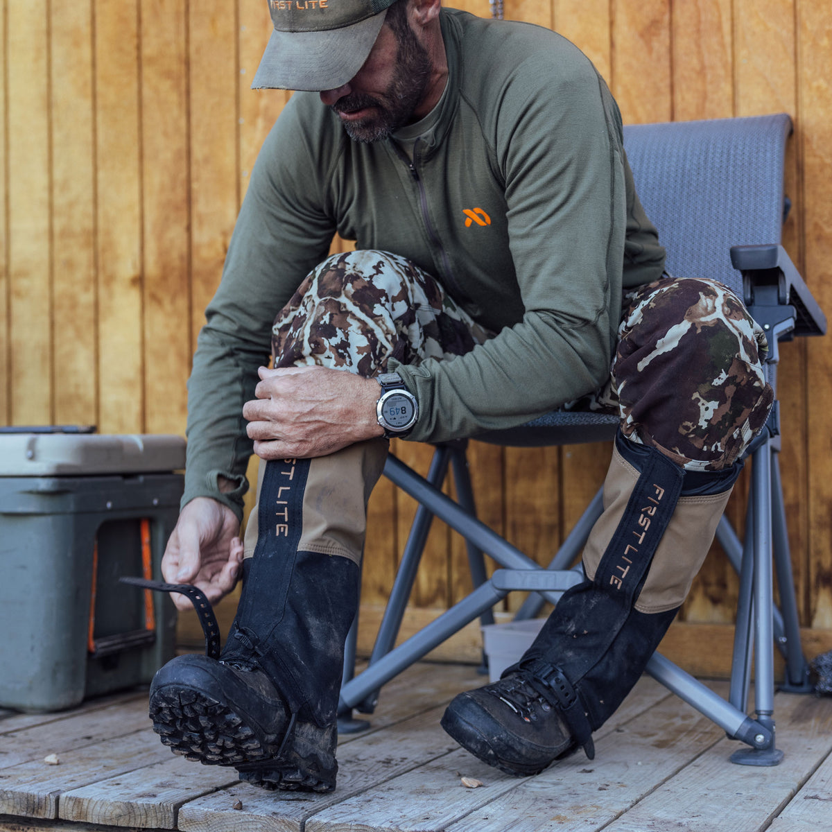 Man on a porch putting on boot gaiters and adjusting strap