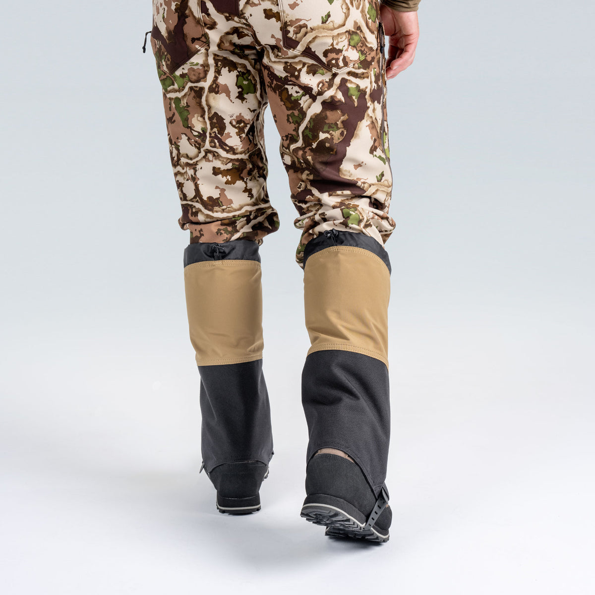 Model wearing First Lite boot gaiters, facing away