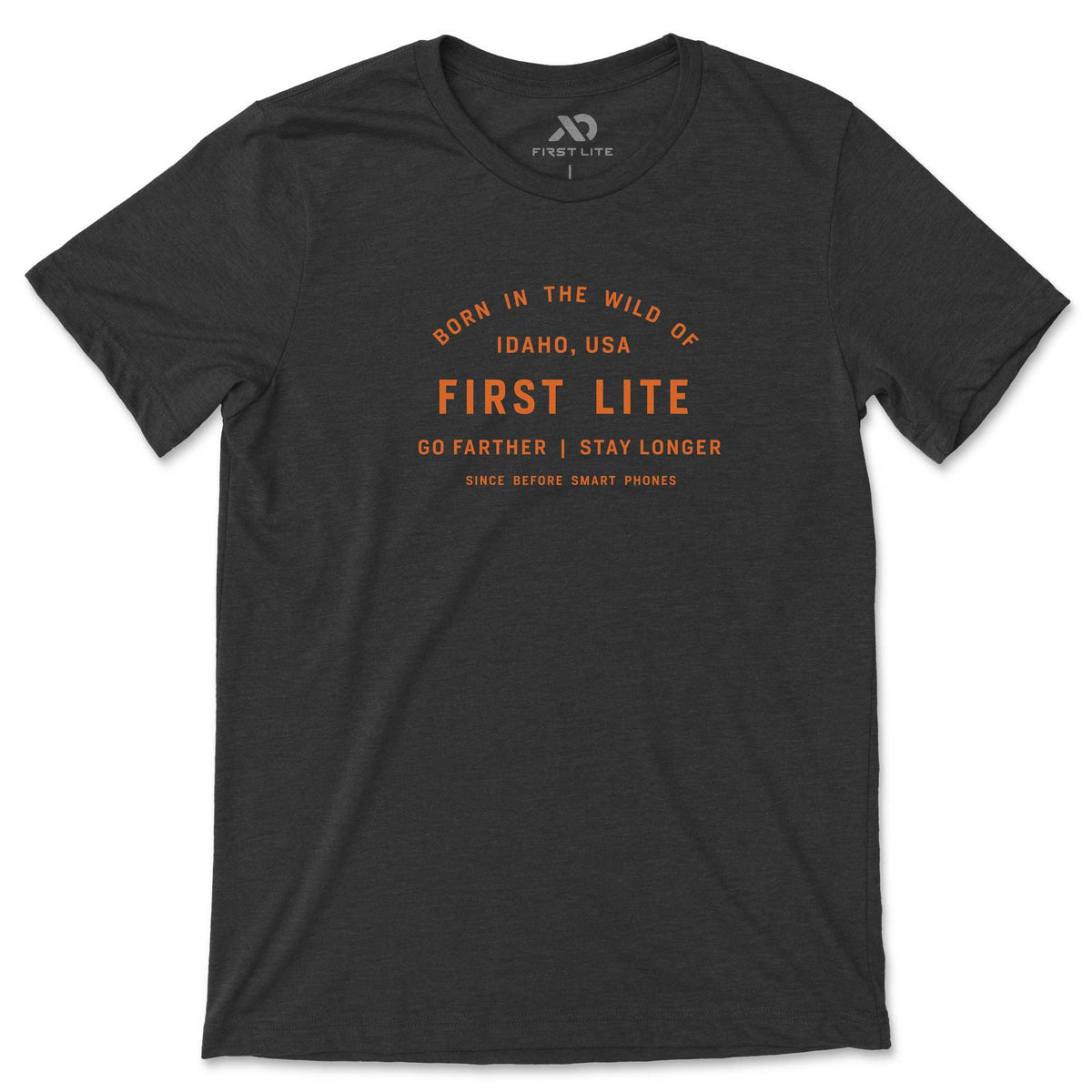 A heather charcoal t-shirt featuring orange text "Born in the Wild of Idaho, USA" and "First Lite - Go Farther | Stay Longer", with a small First Lite logo on the collar.