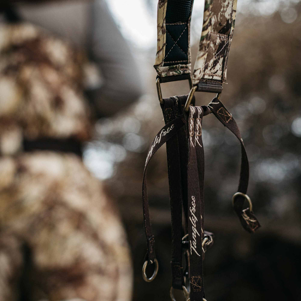 Camouflage duck strap with dark brown Tanglefree-branded loops and bronze metal rings.