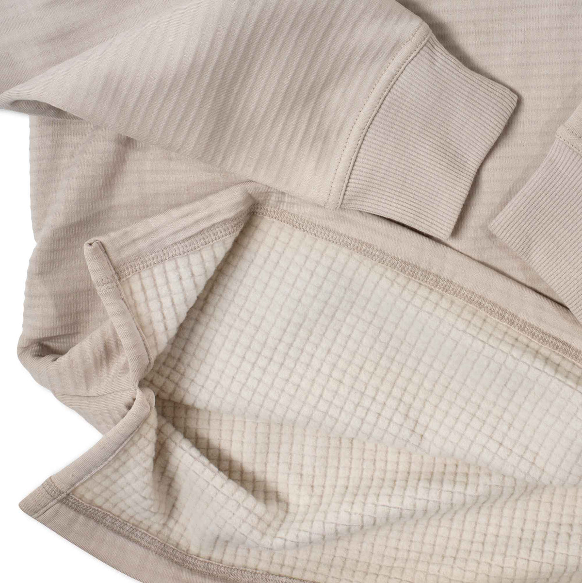Light beige ribbed long-sleeve shirt showing its waffle knit interior lining and ribbed cuffs.