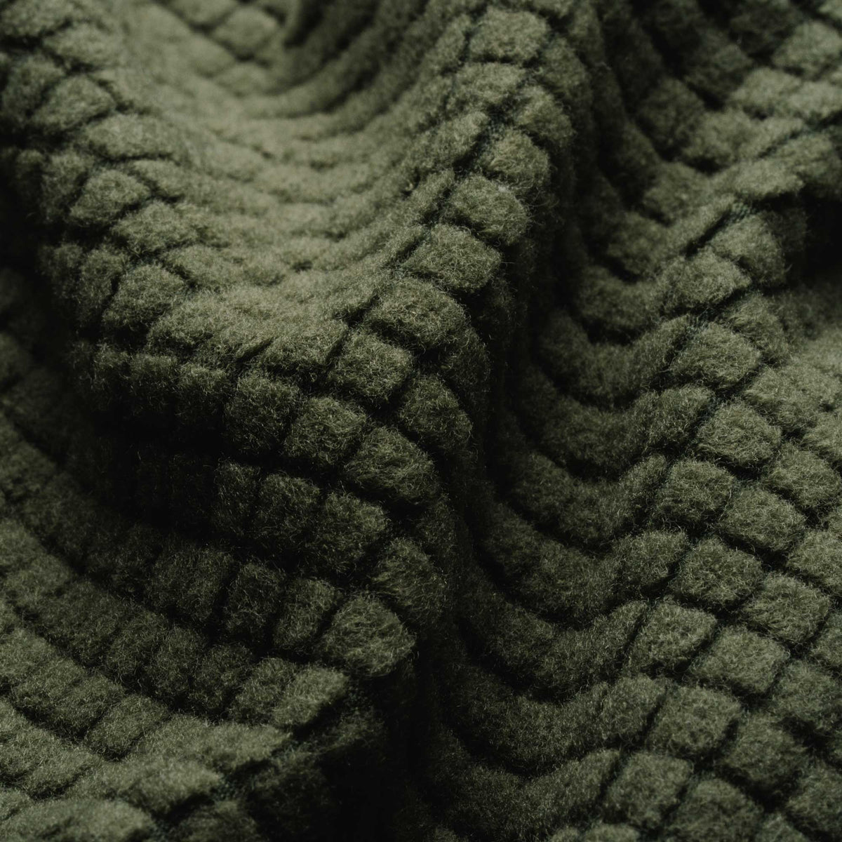 Dark olive green plush fleece fabric with a three-dimensional grid pattern and soft folds.