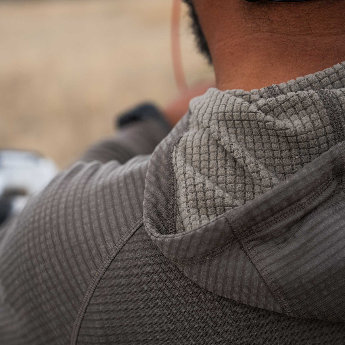 Dark gray hooded shirt with a ribbed body and a lighter waffle-knit hood lining.