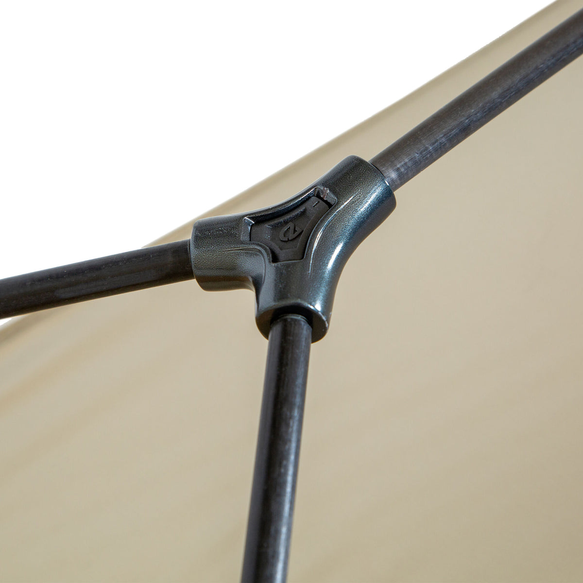Close-up of a dark grey three-way metal joint with an embossed logo, connecting black poles of a light beige canopy.