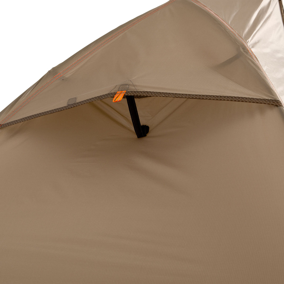 Tan ripstop tent interior showing orange stitching, an orange toggle loop, and a black strap.