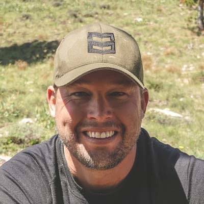 Olive green baseball cap with dark embroidered logo on front.