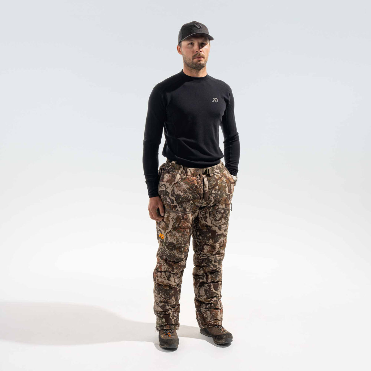 Man wearing black FIRST LITE cap and shirt and camo pants.