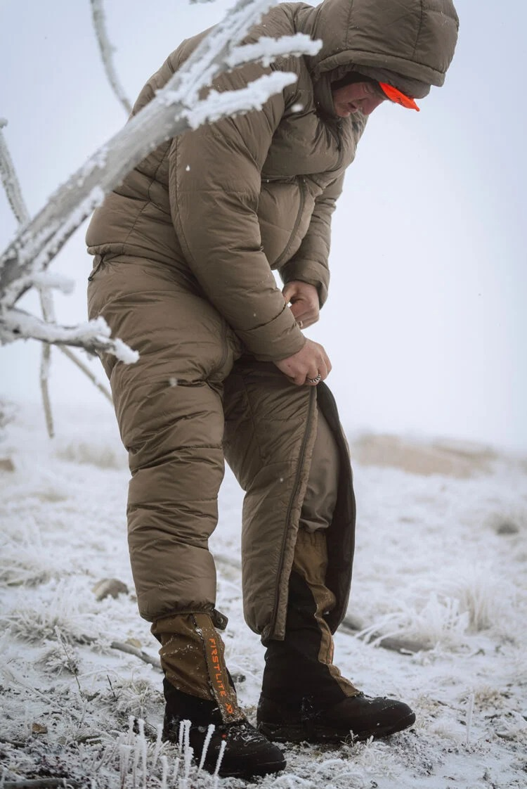 Brown hooded insulated suit with side-zip pants on person in snow.