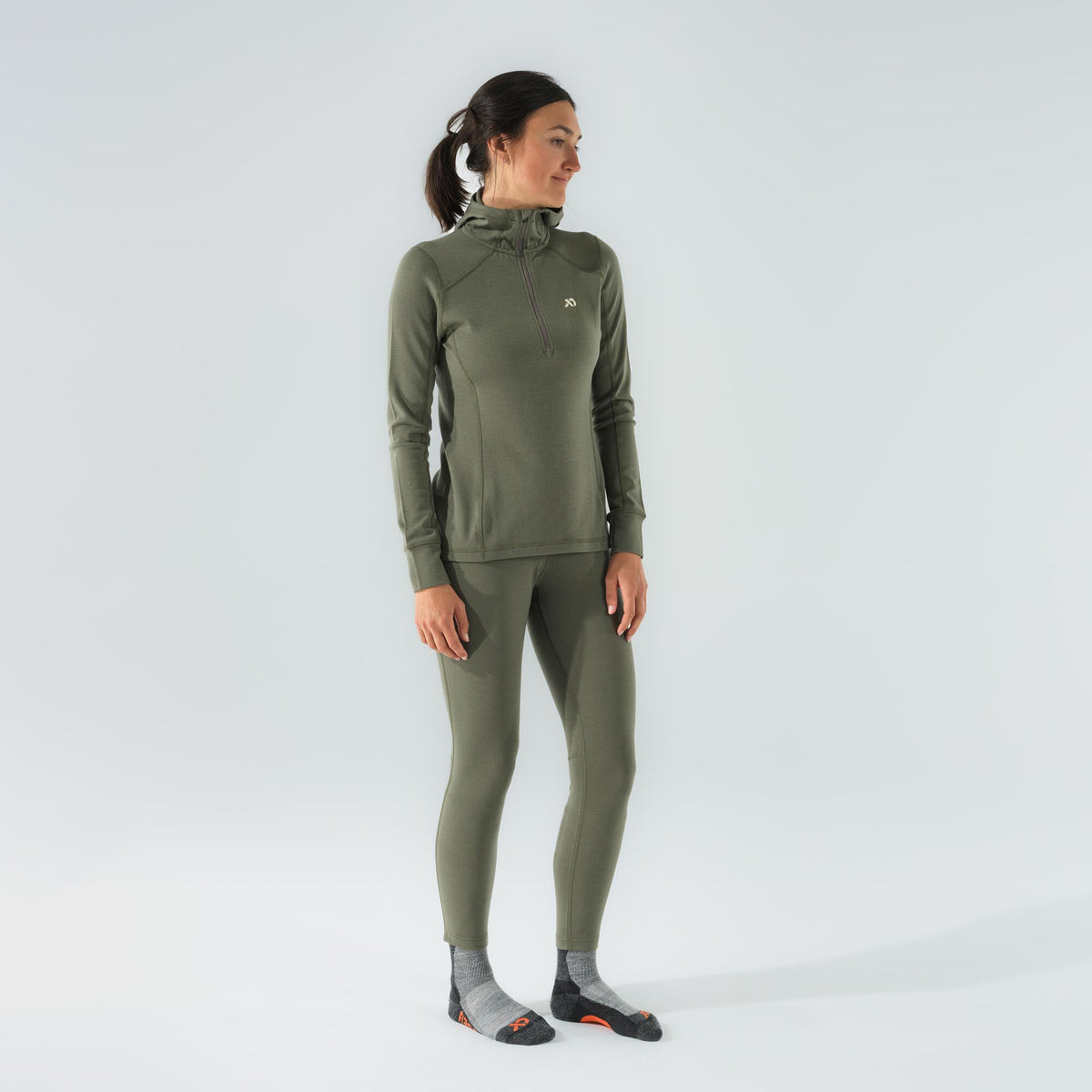 Women's olive green hooded quarter-zip base layer top and matching leggings.