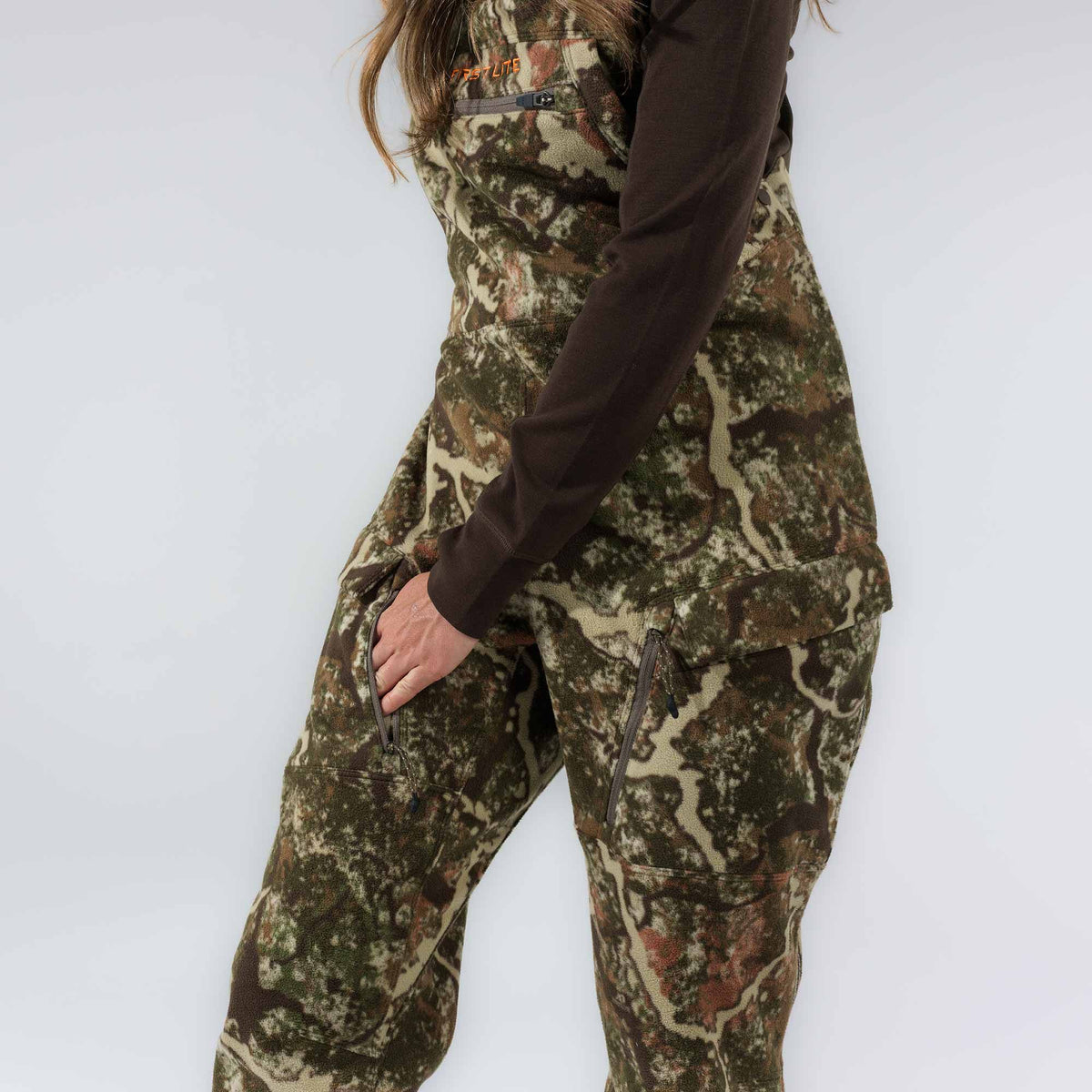 Camouflage fleece hunting bibs featuring zippered pockets and a First Lite logo.